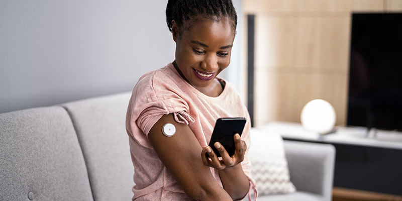 Woman Testing Glucose Level With Continuous Glucose Monitor