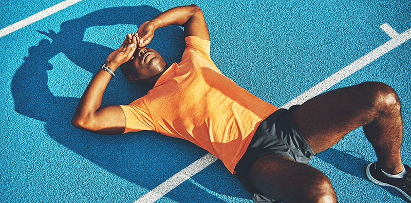 A tired athlete lying on a running track