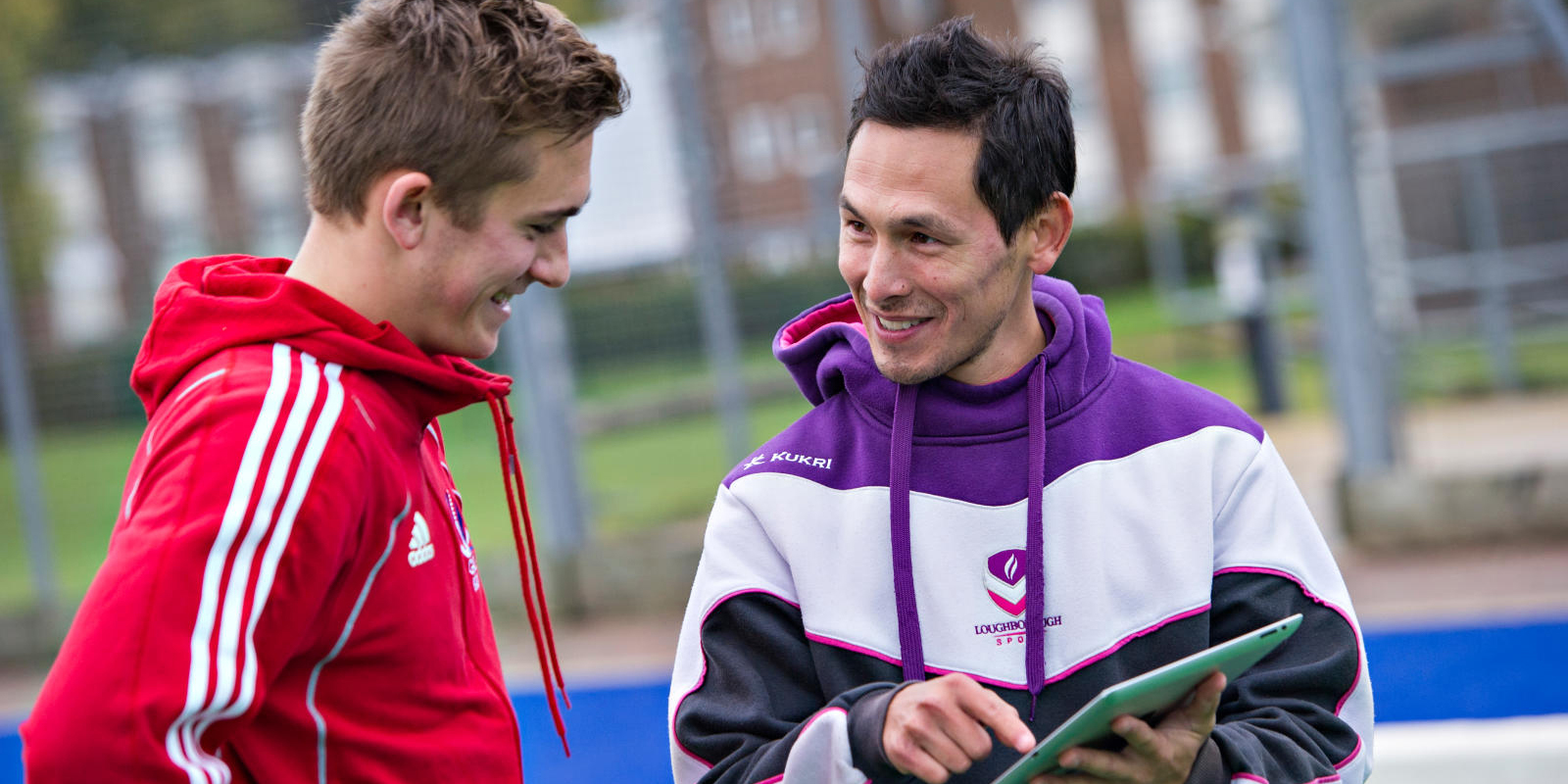 A coach and an athlete look at information on a device