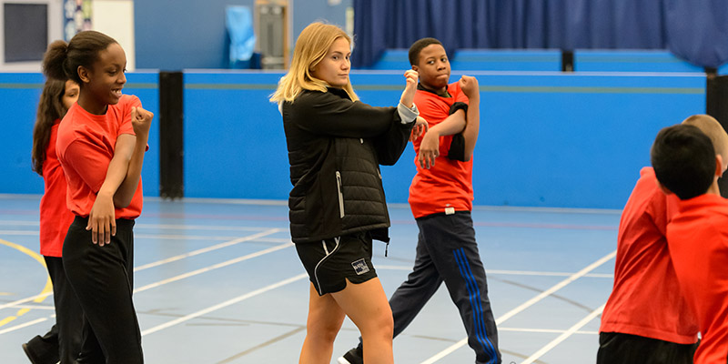 PE teacher stretches with children