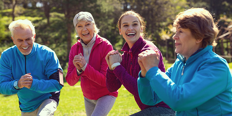 Exuberant aged people exercising in the park