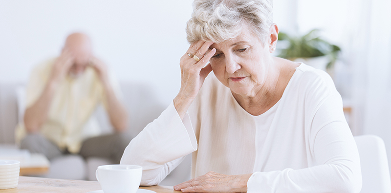 An older lady rubbing her forehead