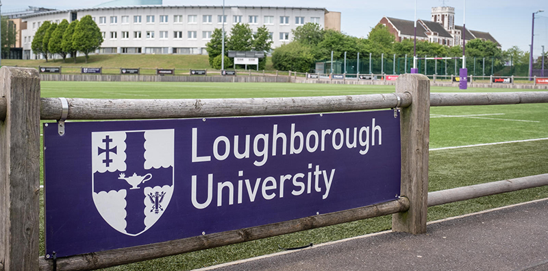 The Loughborough University logo on a banner in front of a rugby pitch