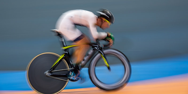 Profile blurred motion of cyclist competing indoor