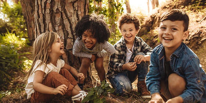 Group of cute kids playing in forest