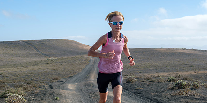 Female athlete running through barren hills