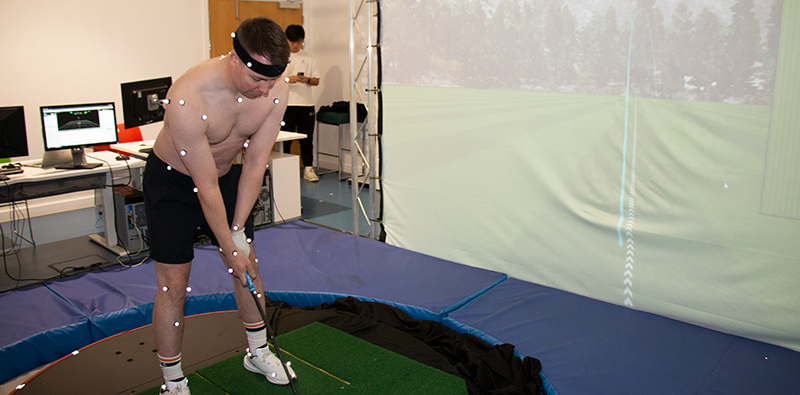 A golfer taking a practice shot in a Loughborough University lab