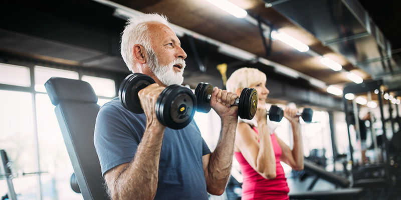 Happy senior people doing exercises in gym to stay fit