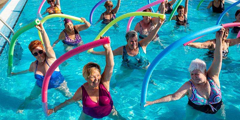 Top view of senior aqua gym class in outdoor pool.