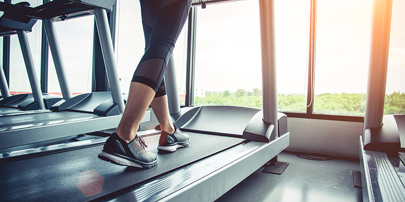 Close up of woman's feet walking on treadmill